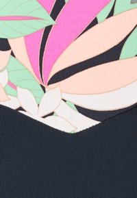 Zwemkleding met een tropisch bloemenpatroon in roze, groen en zwarte elementen, gecombineerd met een gestructureerde donkerblauwe basis.