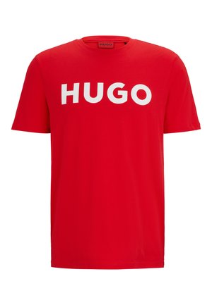 Red cotton t-shirt featuring a bold white "HUGO" logo across the chest. Short sleeves and a standard crew neckline. Smooth texture.