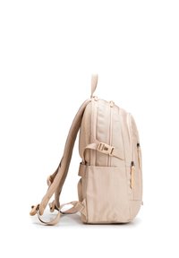 Světle béžový batoh s polstrovanými popruhy, několika kapsami na zip, boční kapsou a nastavitelnými přezkami, zobrazený ze strany.