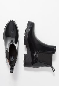 Mustat kumiset nilkkasadenilkkurit, joissa kiiltävä pinta, joustavat sivupaneelit ja kuvioitu musta pohja. Varustettu vetolenkillä helpottamaan pukemista.