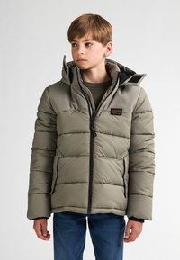 Giacca verde imbottita con colletto alto e cappuccio, caratterizzata da una chiusura con zip, tasche laterali e un patch con logo sul petto.