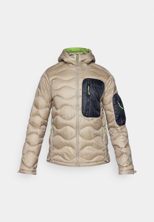 Beige puffetjakke med en tætsiddende hætte, mørkeblå forlommer, grønne lynlåsdetaljer og tekstureret quiltede design over det hele.