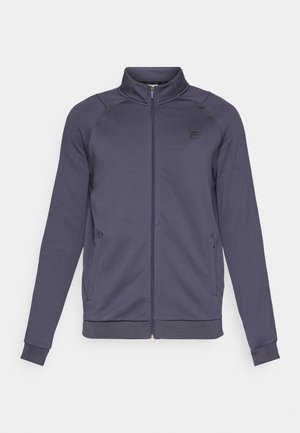 Marineblå zip-up jakke lavet af tekstureret stof. Har sidelommer og ribbede cuffs, med et lille logo på brystet.