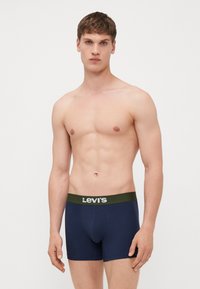 Sötétkék pamut boxeralsó, zöld derékkal, rajta a Levi's logóval. Formázott fazonja és puha textúrája van.