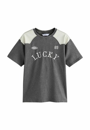Donkergrijze katoenen t-shirt met lichtgrijze schouderpanelen, "LUCKY" in het wit gedrukt en het nummer "89" op de voorkant. Korte mouwen, ronde hals.