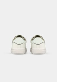 Pair of white casual sneakers shown from the back with light gray heel accents and textured rubber soles on a plain background.