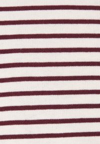 Tissu en coton tricoté présentant des rayures horizontales alternées en bordeaux et crème, avec une texture lisse et des coutures régulières.