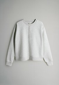 Lichtgrijze pullover met lange mouwen, geribbelde manchetten en zoom, voorzien van een korte knoopsluiting aan de voorkant in het midden.