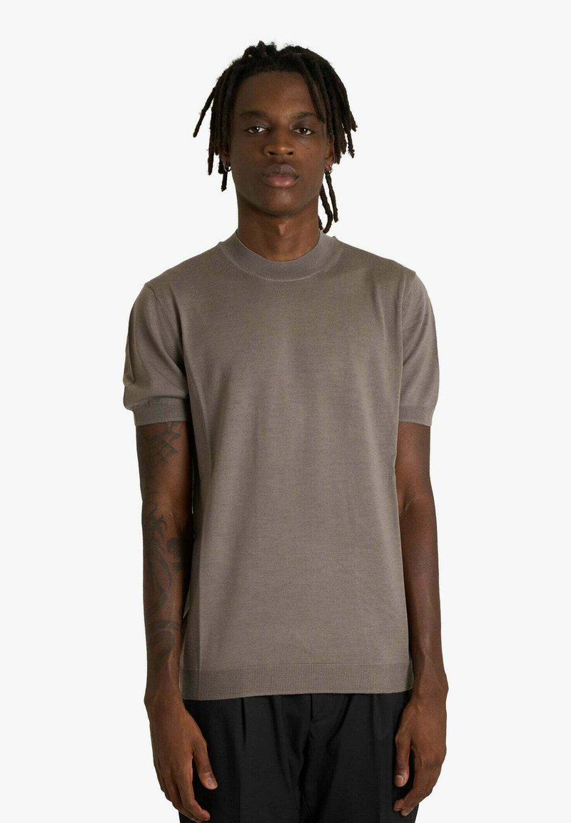 Maglione a maniche corte con scollo a girocollo in taupe. Tessuto a maglia con texture liscia, polsini e orlo a costine, con silhouette aderente.