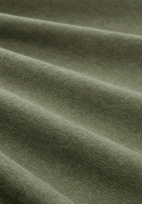 Zielonooliwkowa teksturowana tkanina z subtelnymi falami, ukazująca gładki, tkany wzór. Materiał wydaje się miękki i lekki.