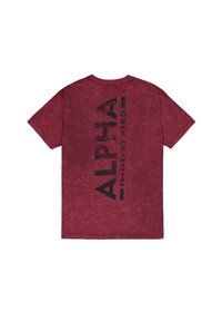 Bordó tričko s krátkým rukávem s vertikálním černým textem "Alpha Industries" na zadní straně, vyrobené z texturované, oprané tkaniny.