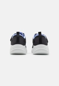Baskets de sport noires avec une tige en tissu texturé, des accents bleu clair et une semelle blanche rembourrée. Elles possèdent des languettes à l'arrière.