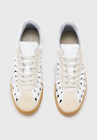 Sneaker bianchi e beige con dettagli intrecciati, pelle liscia, suede testurizzato e suole in gomma naturale. Presentano chiusura con lacci e colletto imbottito.