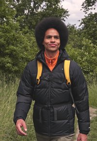 Czarna pikowana kurtka z pomarańczowym wnętrzem, żółtymi paskami i dwoma klamrami na piersiach. Nosi się z pomarańczowym topem na zamek błyskawiczny i jasnymi spodniami.