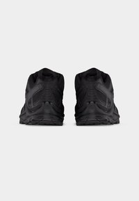 Ζευγάρι μαύρα αθλητικά παπούτσια Salomon, εμφανιζόμενα από πίσω σε απλό ανοιχτό φόντο, αναδεικνύοντας τις λεπτομέρειες της μάρκας και της σόλας.