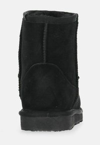 Stivale alla caviglia in suede nero con una finitura testurizzata, dal design semplice, con punta arrotondata e suola in gomma spessa. Presenta cuciture visibili lungo le cuciture.
