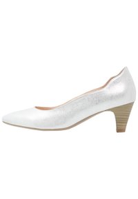 Pompe métallique argentée avec un bout pointu, un petit talon empilé et une finition texturée. Présente un intérieur lisse et des bordures extérieures arrondies.