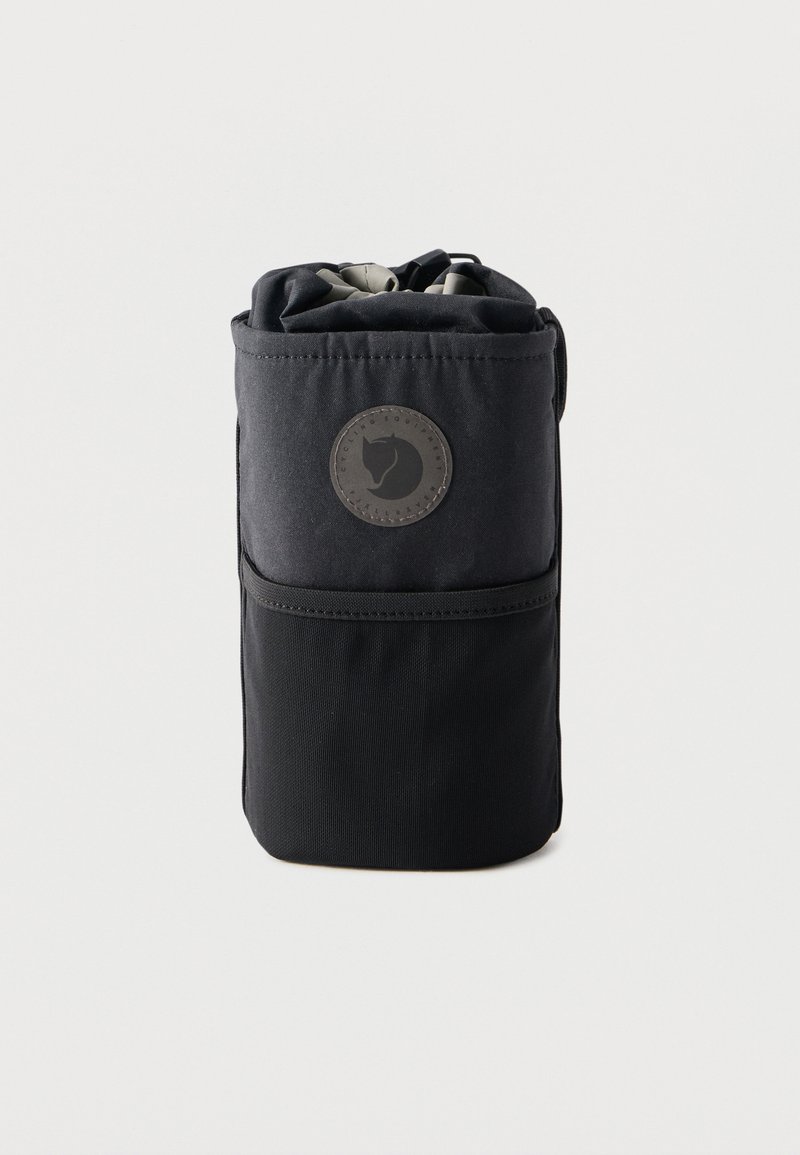 Čierna zrolovaná textilná taška s kruhovou nášivkou loga zobrazujúcou hlavu líšky, na jednoduchom svetlom pozadí.