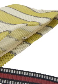 Tkaninowa torba w żółto-szare paski, z teksturowanym materiałem siatkowym, srebrnym zapięciem na zatrzask oraz wzorzystym czarno-czerwonym paskiem.