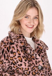 Cappotto in pelliccia finta con stampa leopardata rosa e colletto, caratterizzato da macchie nere e marroni. Include una chiusura a bottoni e un tessuto morbido e testurizzato.