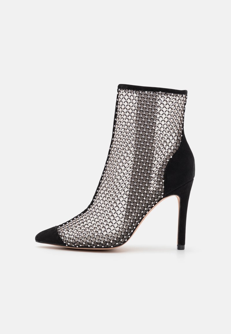Bottine noire à talon haut avec un filet en mesh orné de petits strass et des accents en daim sur l'orteil et le talon.