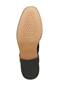 Suela de un zapato de vestir de cuero con orificios de ventilación perforados, área de agarre texturizada y la inscripción "PATENTE ITALIANA GEOX" grabada en la suela.
