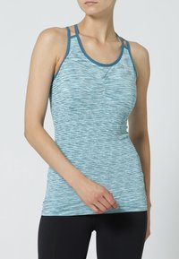 Jasnoniebieski sportowy top na ramiączkach z fakturą przypominającą marmur, cienkimi ramiączkami i dopasowanym krojem. Odpowiedni do aktywności fizycznej.