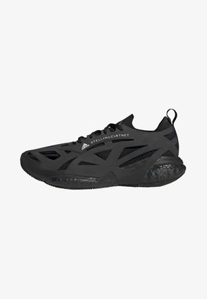 Black athletic shoe featuring a lightweight mesh upper, geometric cutouts, textured rubber sole, and a pull tab at the back for easy wear.