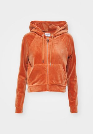 Zachte oranje velours hoodie met rits aan de voorkant, trekkoorden, kangoeroezak en subtiel logo op de linkerborst tegen een witte achtergrond.
