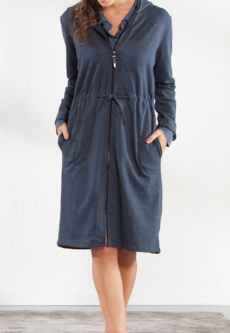 Granatowa sukienka zapinana na zamek z kapturem, elastycznym pasem i kieszeniami. Długie rękawy i teksturowany materiał z otwarciem z przodu.