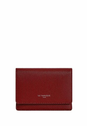 Portefeuille texturé rouge avec une finition lisse, doté d'un design pliable et du nom de marque en relief. Forme compacte et rectangulaire.