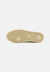 Helles beiges Sneaker-Sohlen mit Fischgrätmuster, kreisförmigen Akzenten und strukturiertem Grip. Glattes Gummi-Material; flaches, niedrig-profiliertes Design.
