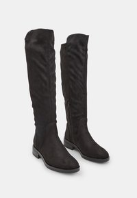 Stivali neri sopra il ginocchio in morbida suede con una finitura liscia e tacco basso a blocco. Presentano una zip laterale per una facile indossabilità.