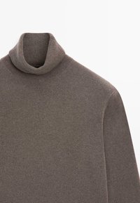 Brązowy sweter z golfem wykonany z miękkiego dzianinowego materiału, z prążkowanym kołnierzem i długimi rękawami, o fakturowanym wykończeniu.