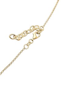 Collier chaîne en or avec fermoir mousqueton et maillons réglables sur fond blanc.