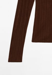 Hnědý proužkovaný top s dlouhým rukávem, který má přiléhavý střih, měkkou texturu a čisté okraje. Vhodný pro vrstvení nebo běžné nošení.