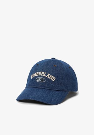 Cappellino da baseball in denim blu con ricamo beige "TIMBERLAND 1973" sulla parte frontale e occhielli di ventilazione sui pannelli superiori.