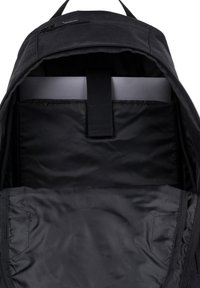 Czarna plecakowa wnętrze z miękkim teksturowanym wykończeniem, z centralną wyściełaną komorą i paskiem do mocowania laptopa.