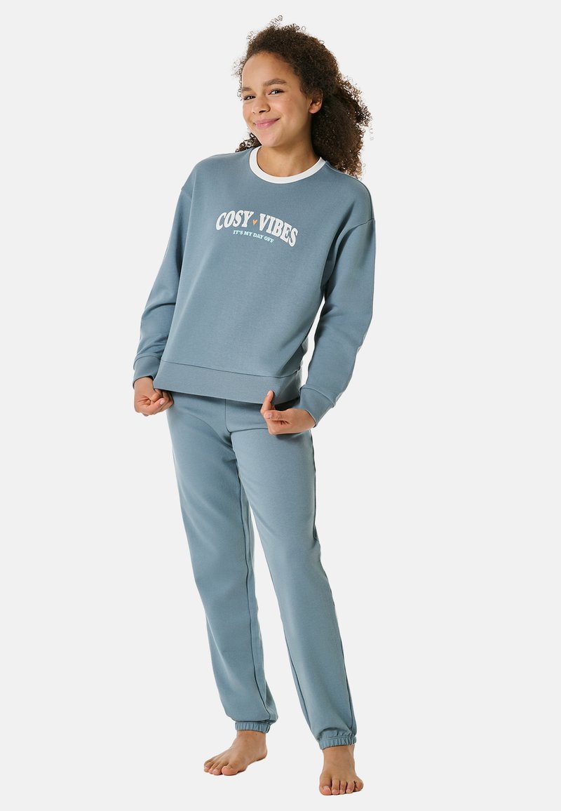Blaues Baumwollsweatshirt mit dem Aufdruck "COSTY VIBES", kombiniert mit passenden blauen Jogginghosen. Beide haben gerippte Bündchen und einen lässigen Schnitt.
