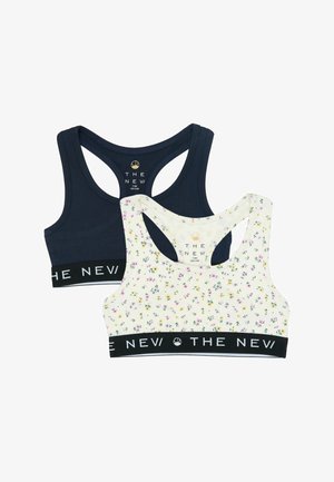 To racerback-sports-bh'er, en mørkeblå og en hvid med små pink og gule blomster, begge med sorte elastikbånd mærket "THE NEV".