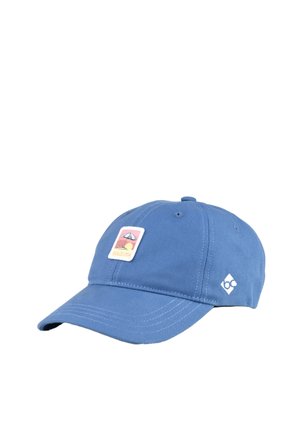 Blaue Baseballkappe mit einem kleinen Aufnäher, der einen Strandsonnenschirm und die Sonne zeigt, beschriftet mit "DOLCE VITA" und einem kleinen weißen geometrischen Logo an der Seite.