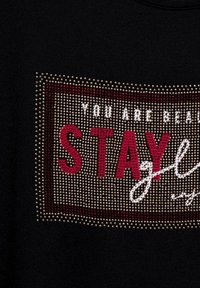 Černá mikina s designem z kamínků a textem "JSI KRÁSNÁ ZŮSTAŇ ZLATÁ" v červených a bílých akcentů.