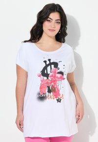 T-shirt bianca in cotone con scollo rotondo e maniche corte, caratterizzata da una grafica di un cane palloncino colorato e testo in dettagli neri e arancioni.