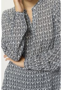 Långärmad skjorta med ett mönster av navy och vita blad, tillverkad av lättviktig tyg, med en avslappnad passform och V-ringning.