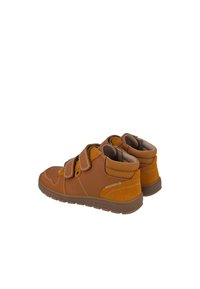 Zapatos de caña alta de cuero y gamuza marrón con dos correas de velcro, punta redondeada, acentos cosidos y suela texturizada.