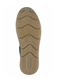 Semelle en caoutchouc épaisse avec un motif beige texturé, présentant des rainures profondes pour une bonne traction. Détail du logo gravé sur le côté.