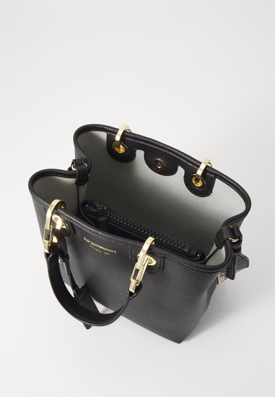 Borsa a mano in pelle nera con finitura testurizzata, accessori in oro e interno di colore chiaro. Presenta una tasca con zip e una tracolla rimovibile.