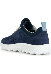Las zapatillas de gamuza azul marino cuentan con un upper texturizado con perforaciones, una suela blanca acolchada y un acento en el talón de color azul claro.