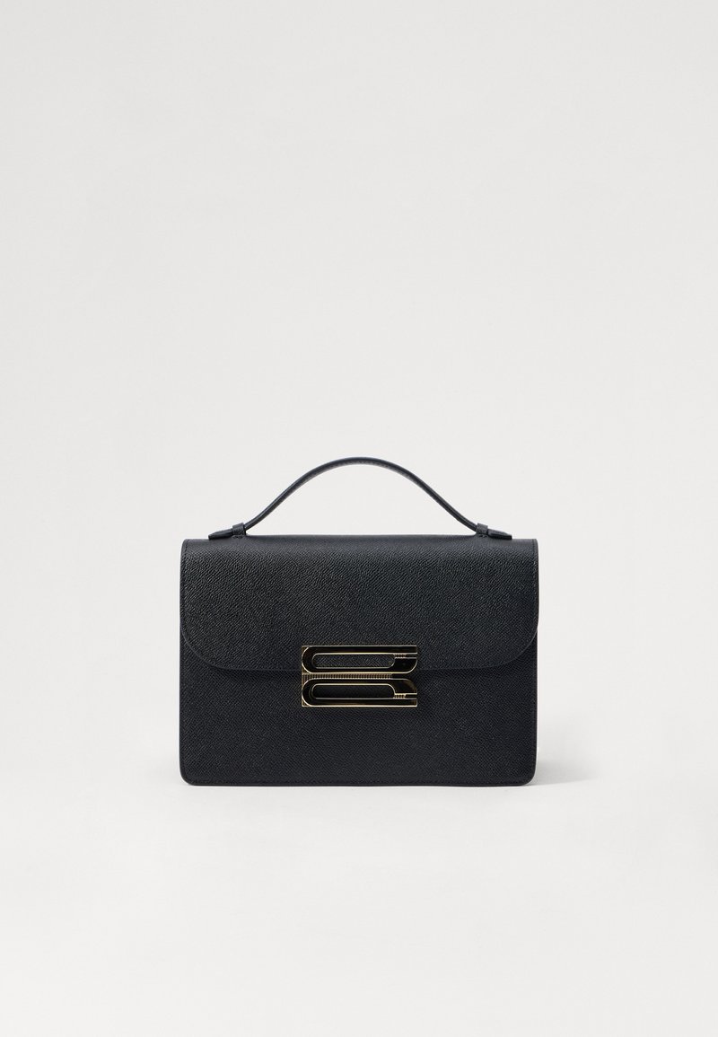 Musta teksturoitu nahkakäsilaukku, jossa on läppäkiinnitys ja kultainen metallikoriste. Kompakti suorakulmainen muoto ja ylälaukku kantamista varten.