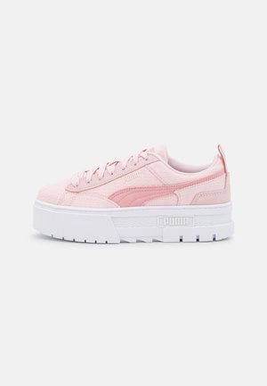 Low platform pink Puma sneaker with textured fabric, side logo, lace-up front, and white chunky sole on plain background.
